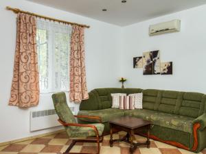 ein Wohnzimmer mit einem grünen Sofa und einem Tisch in der Unterkunft Holiday Home Twin Combo by Interhome in Balatonboglár
