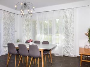a dining room with white curtains and a table and chairs at Holiday Home Francois by Interhome in Balatonberény