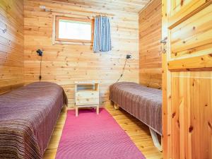 ein Schlafzimmer mit zwei Betten in einer Blockhütte in der Unterkunft Holiday Home Ahven by Interhome in Hiukkajoki + 6 Fotos