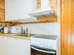 a white kitchen with a sink and a stove at Holiday Home Ahven by Interhome in Hiukkajoki