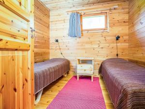 Holiday Home Ahven by Interhome في Hiukkajoki: سريرين في غرفة خشبية مع نافذة