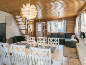 - un salon avec une table, des chaises et un canapé dans l'établissement Holiday Home Aurinkoalppi 12a paritalo by Interhome, à Hyrynsalmi