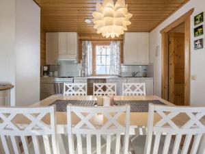 - une cuisine avec une table à manger et des chaises blanches dans l'établissement Holiday Home Aurinkoalppi 12a paritalo by Interhome, à Hyrynsalmi