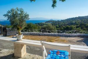 a bench with a view of the ocean at Palaiokastro Traditional House in Mandrákion