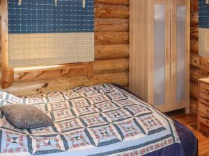 ein Schlafzimmer mit einem Bett mit einer Steppdecke darauf in der Unterkunft Holiday Home Lampitaival 5 by Interhome in Kotila