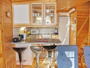 a kitchen with a counter and a refrigerator and chairs at Holiday Home Miilumaja b1 by Interhome in Kotila