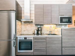a kitchen with a stainless steel refrigerator and cabinets at Holiday Home Vihtarinne b paritalo by Interhome in Hyrynsalmi