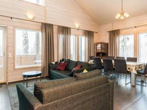 ein Wohnzimmer mit einer Couch und einem Tisch und Stühlen in der Unterkunft Holiday Home Vihtarinne b paritalo by Interhome in Hyrynsalmi + 14 Fotos