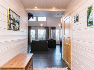 a hallway with wood paneling and a couch in a room at Holiday Home Vihtarinne b paritalo by Interhome in Hyrynsalmi