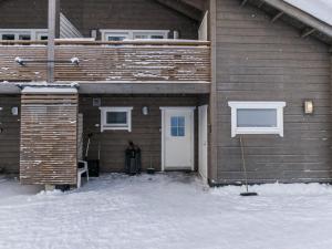 una casa con una puerta blanca en la nieve en Holiday Home Vihtarinne b paritalo by Interhome, en Hyrynsalmi