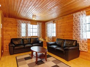 a living room with two leather couches and a table at Holiday Home Ilves by Interhome in Kotila