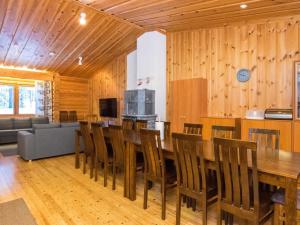 ein Esszimmer mit einem großen Holztisch und Stühlen in der Unterkunft Holiday Home Karhunpesä c by Interhome in Kotila