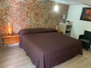 sypialnia z łóżkiem i ceglaną ścianą w obiekcie Bon Jesus Hotel w mieście Costa Esmeralda