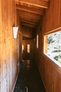 a hallway in a wooden cabin with a window at Arrayan Lake View Mountain Lodge & Casa De Te Arrayan in San Martín de los Andes