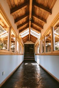 un corridoio vuoto con soffitti e finestre in legno di Arrayan Lake View Mountain Lodge & Casa De Te Arrayan a San Martín de los Andes
