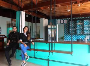 un homme et une femme assis sur une balançoire dans l'établissement PLAYA TILA Lodging & Restaurant, à Tilarán