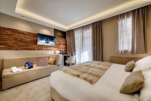 a bedroom with a large bed and a couch at Hotel Le Tremplin in Méribel