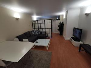 a living room with a couch and a tv at Large modern GF 1-bed apartment Sleeps 2 in London