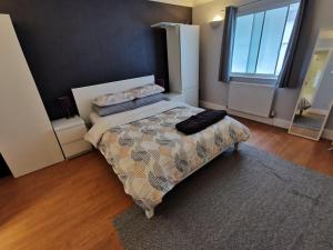 a bedroom with a bed with two pillows on it at Large modern GF 1-bed apartment Sleeps 2 in London