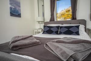 a bedroom with a bed with two towels on it at Rona@Knock View Apartments, Sleat, Isle of Skye in Teangue