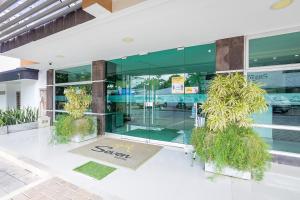 a store front with glass doors and potted plants at Hotel Seven Monteria in Montería