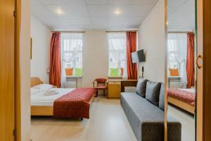 サンクトペテルブルクにあるOctaviana Hotelのベッドルーム1室(ベッド1台、ソファ付)