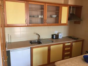 una cucina con mobili in legno e un lavello di Alagoa Praia Altura - Prestige for Home ad Altura