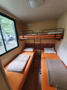 two bunk beds in a small room with a window at NaturExpert Mobil házak-Pelso Kemping Alsóörs in Alsóörs