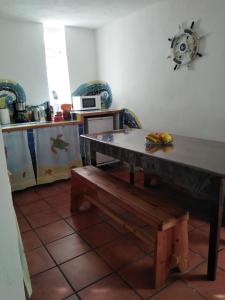 a kitchen with a table and a bench in a room at Casa Jashmine in Arguayo
