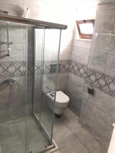a bathroom with a toilet and a glass shower at Kemer Guney Homes Apart in Kemer +26 photos