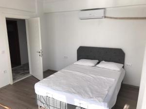 a bedroom with a large bed with white sheets at Kemer Guney Homes Apart in Kemer