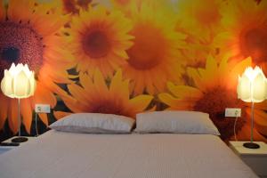 a bedroom with a bed with sunflowers on the wall at EL RAMILLETE in Soria
