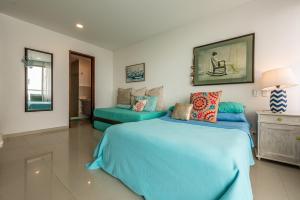 Un dormitorio con una cama azul y un sofá. en Edificio Morros Vitri Lujo con Panorama, en Cartagena de Indias 44 fotos más