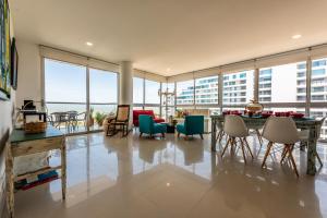Una sala de estar con mesa y sillas y ventanas. en Edificio Morros Vitri Lujo con Panorama, en Cartagena de Indias