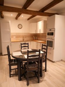 a kitchen with a dining room table and chairs at Gite de charme Les Buissonnets in Plesder