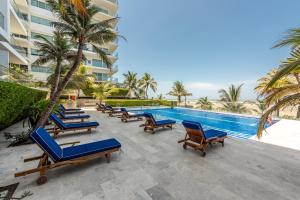 una fila de tumbonas azules junto a una piscina en Edificio Morros Vitri Lujo con Panorama, en Cartagena de Indias