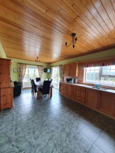 a kitchen with a table and a dining room at Cosy Family home in Burnfoot