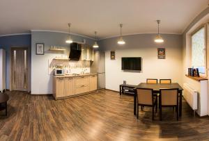 a living room with a table and a kitchen at Стильные апартаменты в новострое in Kyiv