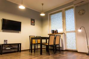 a dining room with a table and chairs and a tv at Стильные апартаменты в новострое in Kyiv