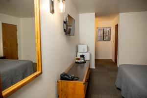 a room with two beds and a mirror and a desk at Eagle Cap Chalets in Joseph