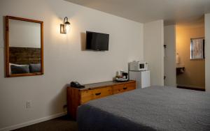 Habitación de hotel con cama y espejo en Eagle Cap Chalets, en Joseph