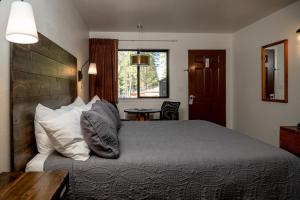 a bedroom with a bed with pillows and a table at Eagle Cap Chalets in Joseph