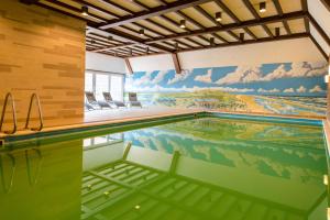 an indoor swimming pool with a mural on the wall at Hotel Hofker in Nes