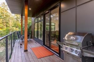 a kitchen with a grill on a deck at Storm Cove Suites in Ucluelet