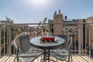 a table on a balcony with three apples on it at Paamonim Hotel Jerusalem in Jerusalem