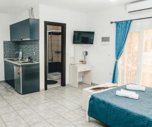 a room with a bed and a sink and a kitchen at Victory Apartments & Hotel (Block C) in Samothraki