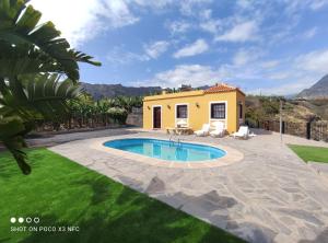 um quintal com uma piscina e uma casa em Casa Pedro em Tazacorte