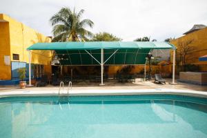 ein Schwimmbad mit einem Zelt, einem Tisch und Stühlen in der Unterkunft Hotel La Casona Real in Cozumel