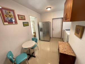 a kitchen with a table and a stainless steel refrigerator at Rim Canal Cottage 'Yellow House' with Canal Views & Boat Dock cottage in Okeechobee