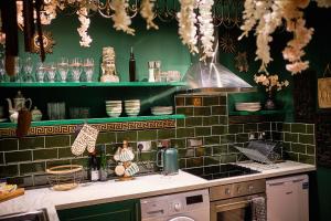 een keuken met groene betegelde muren en een aanrecht bij The Emerald Suite by Margate Suites in Margate
